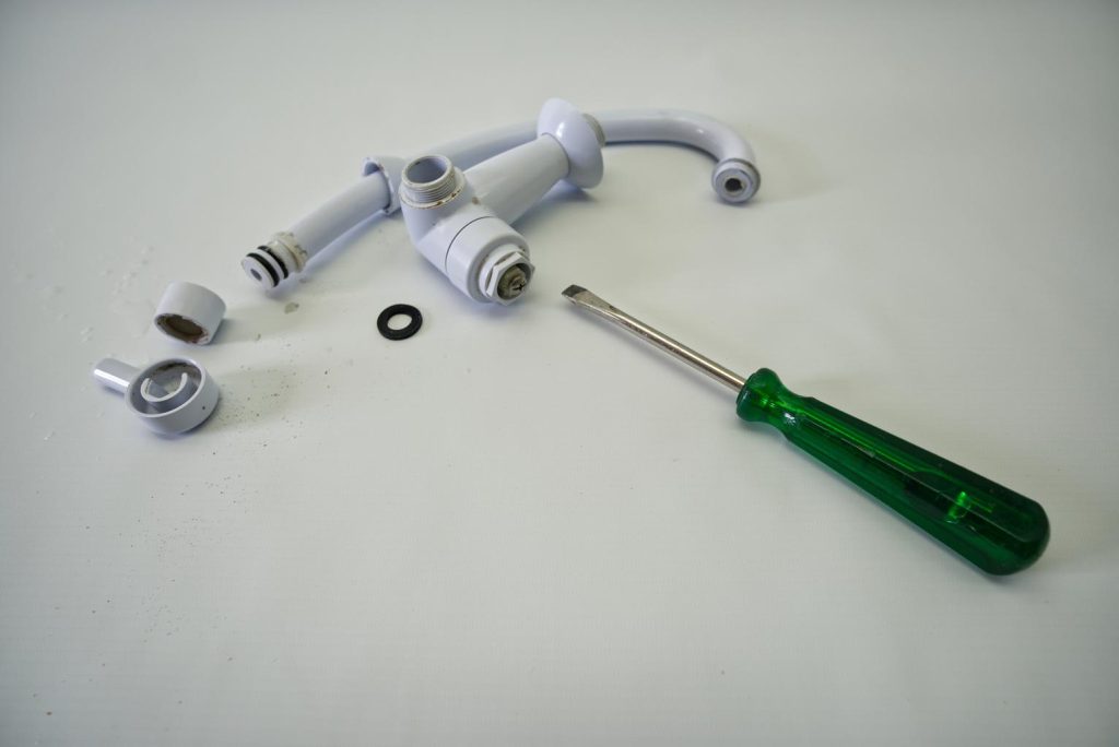 removing a sink faucet handle with a screwdriver